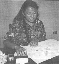 Elizabeth Aju de Tómas signing incorporation papers for FUNDAMARCOS